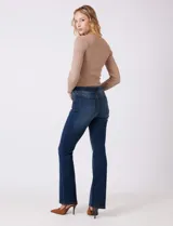 Jean elastizado de mezclilla azul oscuro, tiro alto, con pierna bootcut. Presenta costuras visibles y cinco bolsillos.