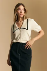 Falda larga de mezclilla color crema, de corte recto y talle alto, con costuras visibles en contraste y abertura frontal.