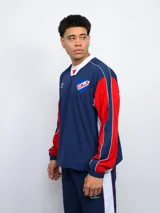 Buzo deportivo azul marino, rojo y blanco con escudo del Club Nacional de Football en el pecho y logo de Umbro en la manga.