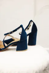 Zapato de tacón bajo color negro, con punta fina y tiras cruzadas sobre el empeine.