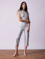 Pantalón capri marca Zac & Rachel, confeccionado en gabardina elastizada a rayas verticales celestes y blancas. Presenta pretina ancha elastizada y ruedo con bordado floral.