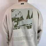 Buzo color beige de corte oversize con estampa en la espalda de botellas de vino y texto en verde.