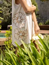 Vestido corto gris con bordado floral en el frente, corte holgado y mangas cortas.