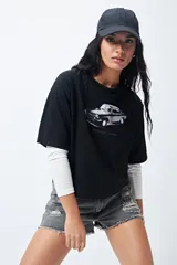 Remera cropped negra con estampa frontal estilo vintage de un auto y mangas ranglan.