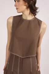 Blusa corta color marrón, sin mangas, con cuello redondo y pespuntes en contraste color blanco.