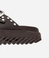 Sandalias planas flatform color marrón con puntera redonda, correas con hebillas plateadas y tachas redondas. Suela track.