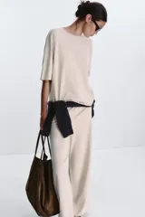 Camiseta color beige de corte amplio, cuello redondo y mangas cortas.