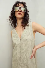 Vestido corto con estampado geométrico en tonos beige y blanco, con escote en V, sin mangas y cierre frontal con botones.