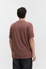 Remera marrón de manga corta con cuello redondo y estampado con texto en el frente.