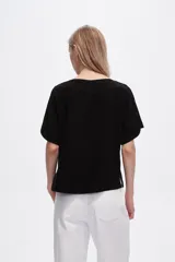 Blusa negra de viscosa, corte holgado y cuello redondo.