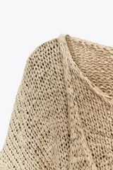 Jersey color beige de punto calado con efecto doble, cuello redondo y manga larga.