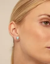 Aro piercing dorado con perla blanca en el centro.