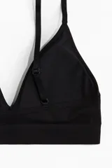 Soutien negro de punto suave con breteles ajustables, copas forradas con relleno extraíble, sin cierre ni aros.