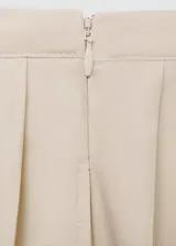 Falda midi color beige, de diseño evasé con tablas y cierre lateral invisible.