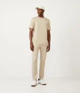 Pantalón slim color beige confeccionado en sarga texturizada de algodón y elastano, con trabillas en la cintura, cierre con botón y cremallera, bolsillos delanteros y traseros con solapa.