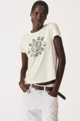 Camiseta color lila de algodón, con cuello redondo y mangas cortas. Estampado frontal con diseño varsity en color blanco con el texto "Zara A Coruña Est. 1975".