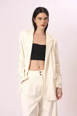 Pantalón palazzo color crudo con bordados florales en los laterales.