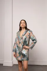 Blazer corto con estampado abstracto en tonos celeste, verde, naranja y dorado. Tiene cuello solapa, cierre frontal con botones y mangas largas.