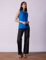 Blusa sin mangas color amarillo, con cuello redondo con frunces delanteros y abertura con botón en la espalda.