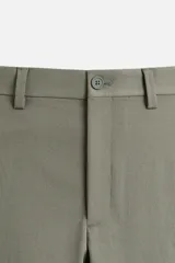 Pantalón chino negro slim fit confeccionado en tejido técnico de secado rápido. Cuenta con bolsillos frontales y traseros de vivo. Cierre frontal con cremallera y botón.