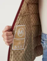 Campera liviana Michael Kors color blanco, con cierre frontal metálico dorado, bolsillos delanteros con cierre, capucha desmontable y avíos metálicos con logo.