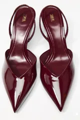 Zapato destalonado acharolado color borgoña, con escote en pico, cierre con tira trasera ajustable, tacón fino y punta fina.
