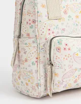 Mochila negra de cuerina con doble asa corta de mano con textura, correas regulables, cierre superior, bolsillo frontal con cierre, bolsillos laterales y tag en relieve.