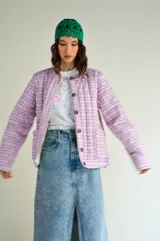 Campera con estampado a cuadros en tonos lila y verde, con botones marrones y bolsillos frontales.