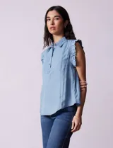 Blusa celeste sin mangas en tencel, marca Zac & Rachel. Cuello con solapa y abertura con botones. Mangas con frunces.