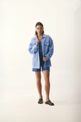 Sandalias de cuero color marrón claro, con punta descubierta y diseño tipo mule. Presentan tachas doradas en el borde superior y suela plana con pequeño tacón. Fabricadas en Uruguay.