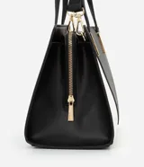 Bolso satchel mediano bicolor, negro en la parte superior y blanco en la inferior, con detalles metálicos dorados en las asas. Incluye correa larga desmontable y cierre de cremallera.