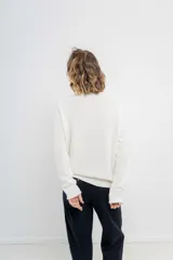 Sweater azul de punto medio, amplio, suave, con escote a la base y puños en mangas y en acabado inferior.