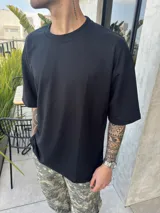 Remera negra de algodón pesado, corte oversize y cuello redondo.