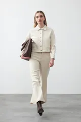 Pantalón de denim azul oscuro con corte flare, ajustado en la cadera y amplio en el ruedo. Presenta pespuntes a contratono en color blanco que resaltan las costuras.