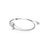 Pulsera rígida plateada con dos dijes cuadrados, uno celeste y otro transparente, rodeados de cristales.
