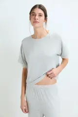 Conjunto de pijama negro, compuesto por una remera de manga corta con detalle de encaje en los puños y un pantalón largo de corte recto.