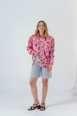 Camisa blanca con estampado de flores rojas, palmeras, piñas y tucanes.