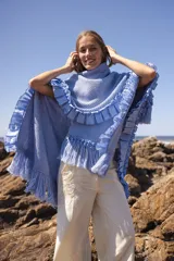 Ruana marrón tejida en lana merino con detalles de lino y flecos.