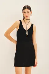 Falda mini negra de tejido de punto con cintura elastizada y diseño plisado.