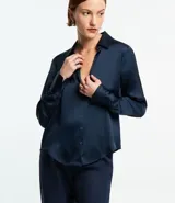 Camisa de satén color verde oliva, de manga larga con puños abotonados y cuello inglés.