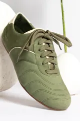 Zapatillas acordonadas color beige con detalles en blanco.