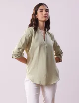 Blusa verde claro con escote en V y mangas 3/4 regulables con presilla y botón.