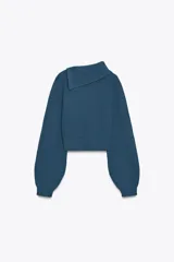 Sweater color crudo de tejido de punto acanalado, con cuello solapa abotonado y mangas largas abullonadas.