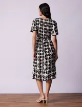 Vestido estampado con escote en V con frunces, cintura elastizada con lazo de ajuste y mangas cortas con detalles en broderie.