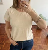 Remera color beige de corte clásico con mangas cortas y cuello redondo.