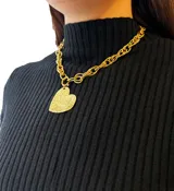 Collar dorado con cadena de eslabones gruesos y dije de corazón texturizado.