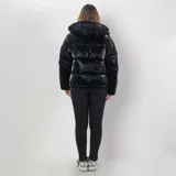 Campera puffer negra de poliéster con interior acolchado, capucha ajustable, cuello alto, cierre frontal con cremallera y botones a presión, dos bolsillos externos con cierre y sistema de ajuste regulable en la parte baja.