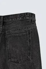 Bermuda de jean azul con lavado medio, corte holgado, cinco bolsillos, roturas y cierre frontal con cremallera y botón.