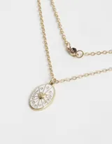 Collar corto doble dorado con dije ovalado blanco con corazón dorado y strass.