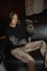 Buzo de algodón negro con bordado floral en las mangas, diseño oversize y cuello a la base.